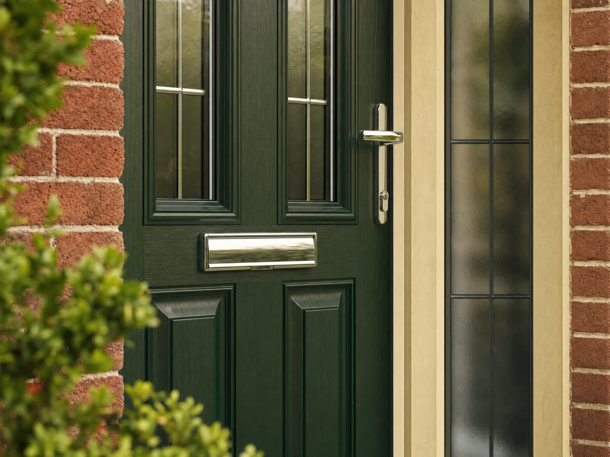 Forest-green composite front door with woodgrain finish on a brick porch